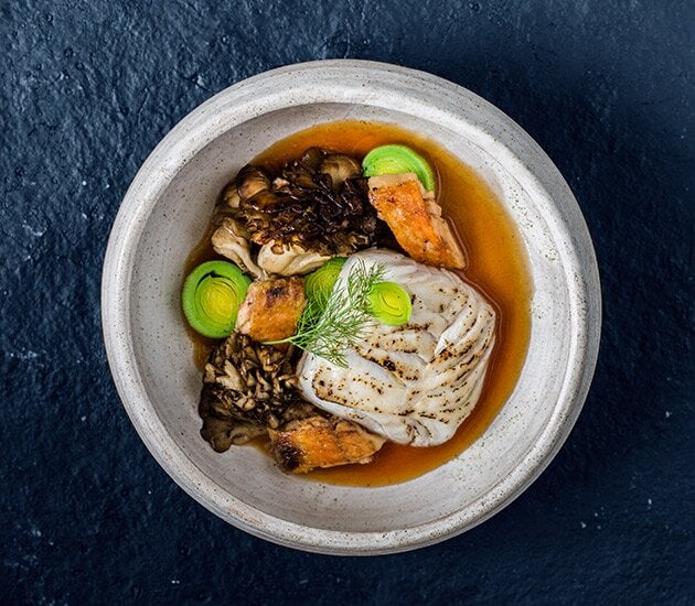 Roasted fillet of Skrei, smoked leeks, confit chicken wings, maitake mushrooms