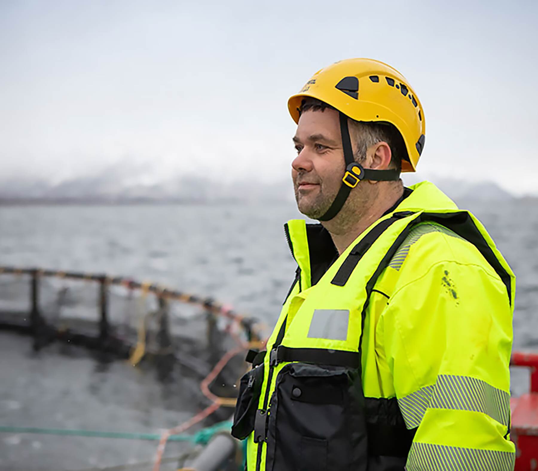 Salmon farmer looking out on sea pen